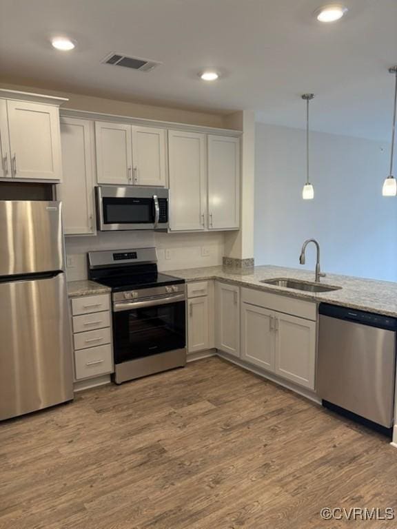 10530 Stony Bluff Dr Unit 304, Ashland, VA 23005 - kitchen featuring visible vents, a sink, light stone counters, wood finished floors, and stainless steel appliances
