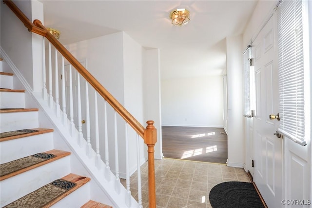 staircase with baseboards and wood finished floors