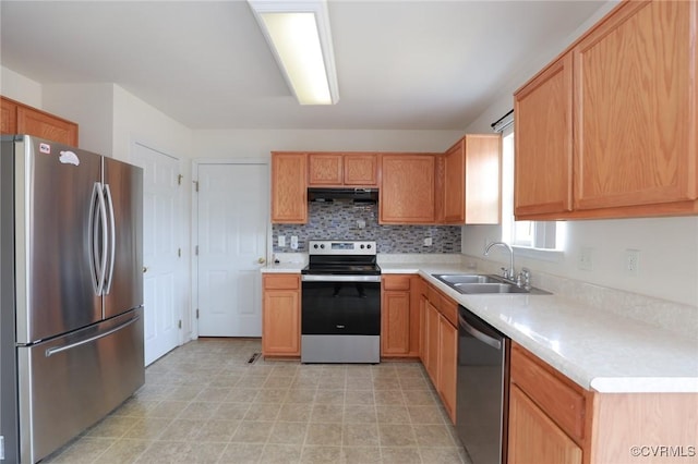 kitchen with under cabinet range hood, a sink, light countertops, appliances with stainless steel finishes, and decorative backsplash