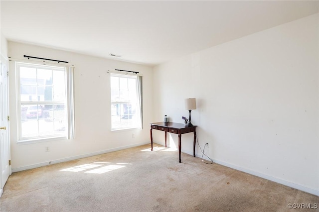 spare room featuring carpet, visible vents, and baseboards