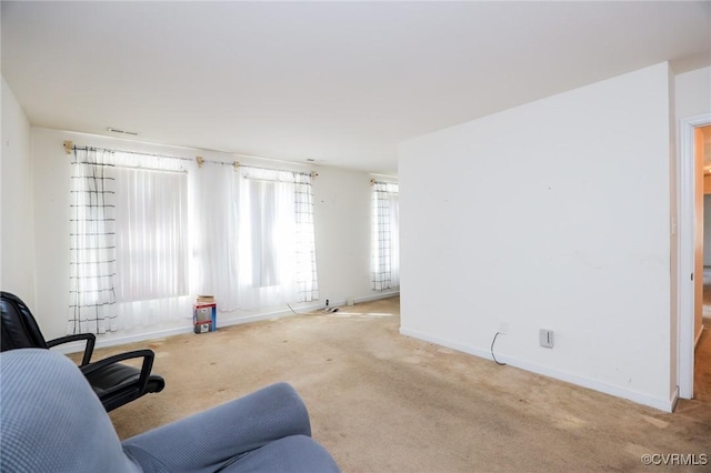 living area with visible vents, baseboards, and carpet flooring