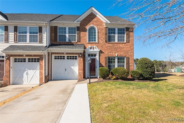 view of front facade with a garage, a front yard, concrete driveway, and brick siding