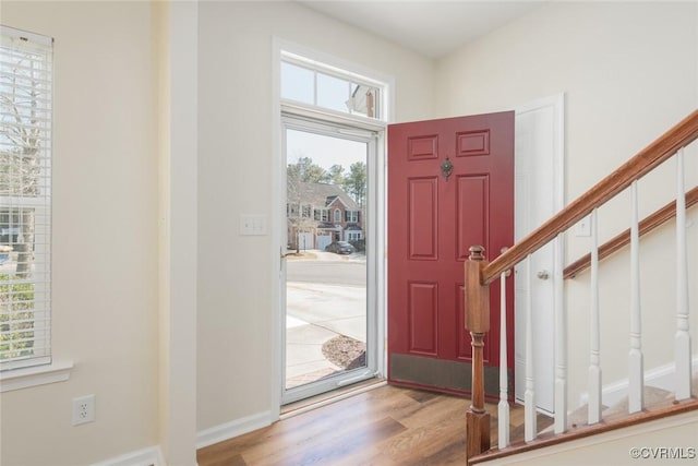 entrance foyer with stairway, baseboards, and wood finished floors