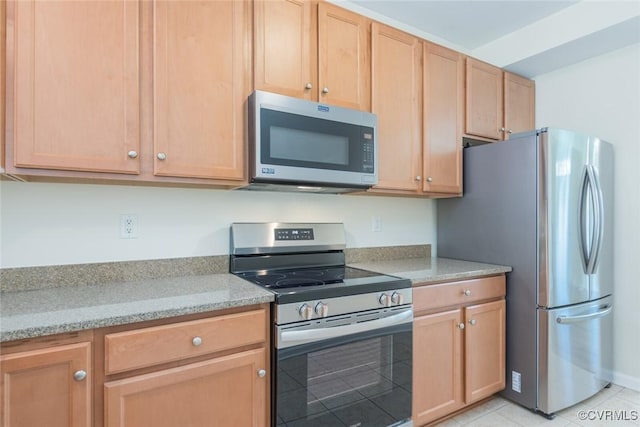 kitchen with light stone countertops, light brown cabinets, appliances with stainless steel finishes, and light tile patterned floors