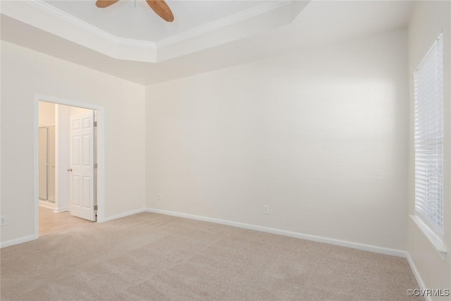 unfurnished room with light carpet, baseboards, a tray ceiling, and ornamental molding