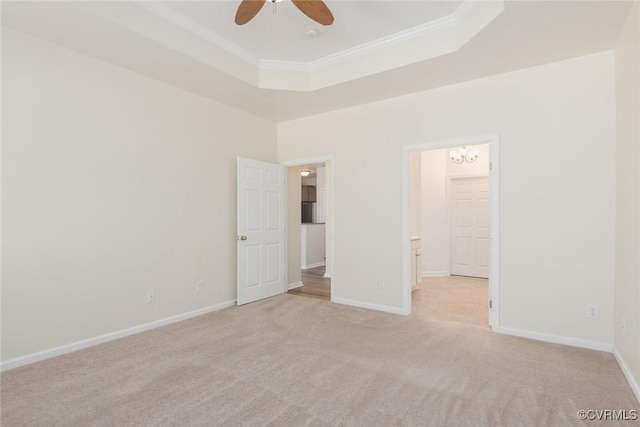 unfurnished bedroom featuring a raised ceiling, light colored carpet, and crown molding