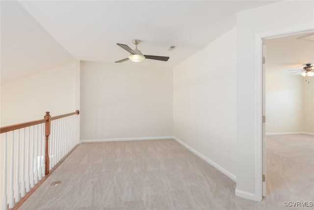 unfurnished room featuring carpet, visible vents, baseboards, and ceiling fan