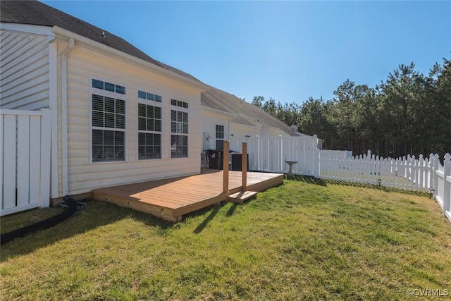 back of property featuring a fenced backyard, a yard, and a wooden deck