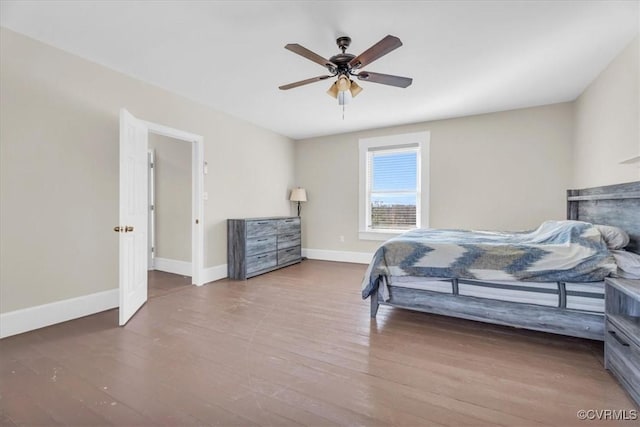 bedroom with a ceiling fan, baseboards, and wood finished floors