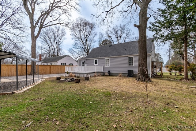 rear view of house with a chimney, a lawn, central AC, fence, and a wooden deck