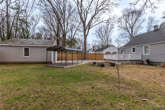 view of yard with a detached carport and a deck