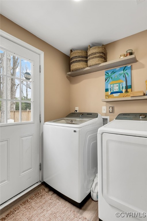 clothes washing area featuring laundry area, washer and clothes dryer, and light wood-style floors