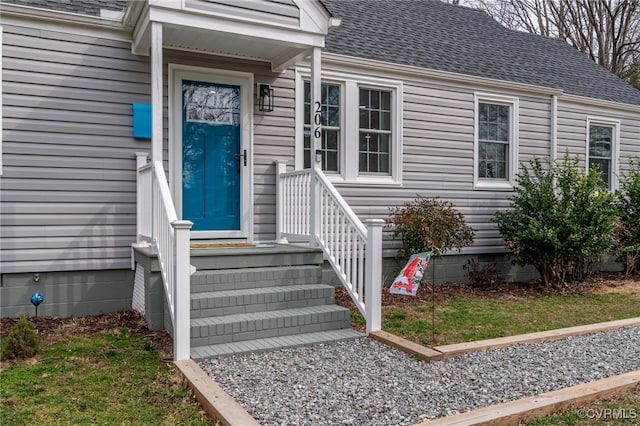 view of exterior entry featuring a shingled roof and crawl space