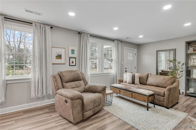 living area featuring recessed lighting, a healthy amount of sunlight, visible vents, and light wood-style flooring