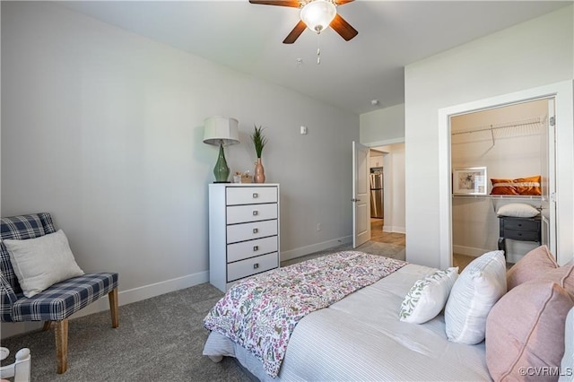 carpeted bedroom featuring freestanding refrigerator, a ceiling fan, and baseboards