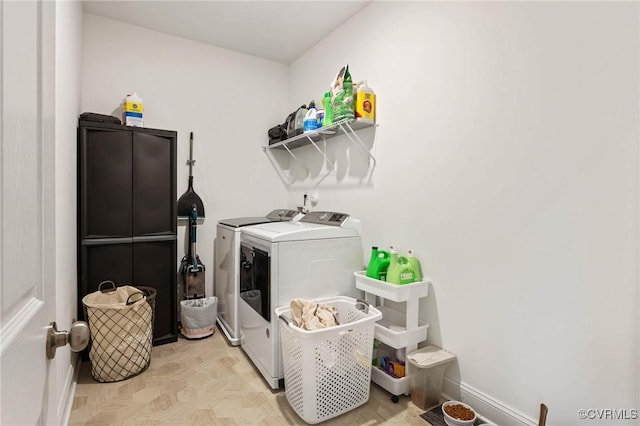 laundry area with laundry area, baseboards, and separate washer and dryer