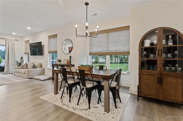 dining space with recessed lighting, visible vents, an inviting chandelier, light wood-type flooring, and baseboards