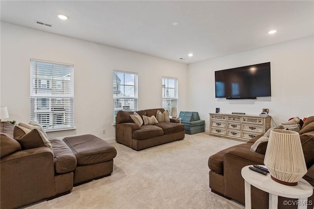 living area featuring light colored carpet, visible vents, and recessed lighting