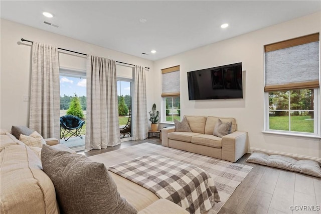 living room featuring baseboards, wood finished floors, visible vents, and recessed lighting