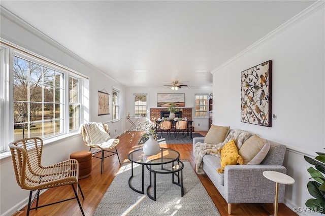 living room with ornamental molding, wood finished floors, a ceiling fan, and baseboards