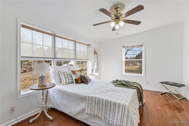 bedroom featuring crown molding, ceiling fan, wood finished floors, and baseboards