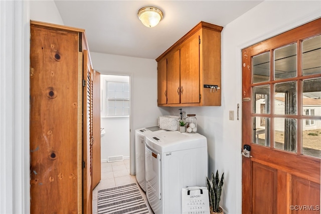 washroom with cabinet space, light tile patterned floors, visible vents, and washing machine and clothes dryer