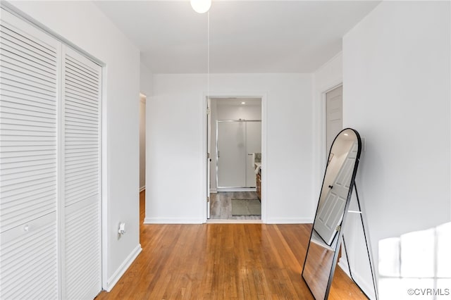 hallway with wood finished floors and baseboards