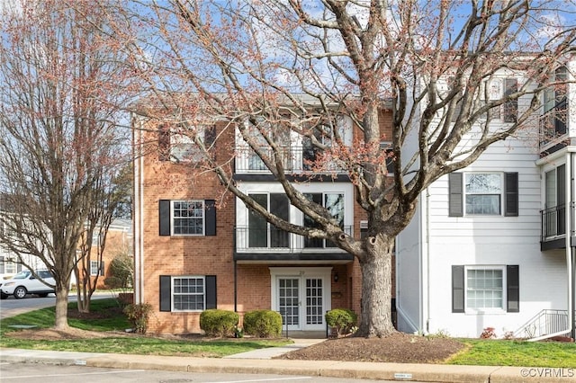 view of property featuring brick siding and french doors