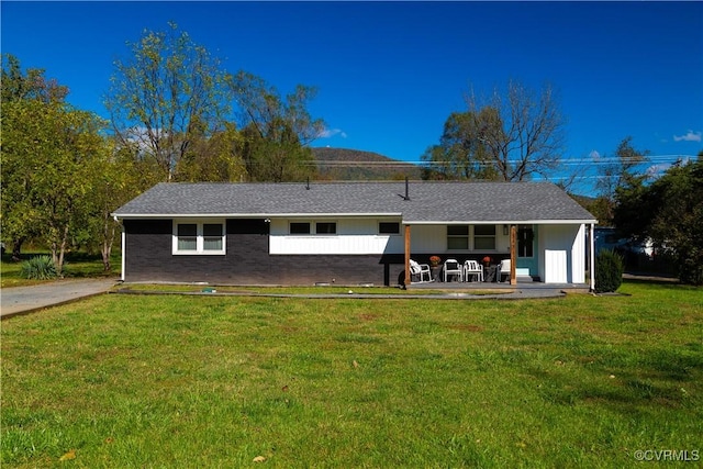 back of house with brick siding and a yard