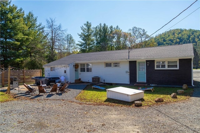 ranch-style house with a patio area, brick siding, fence, and central AC unit