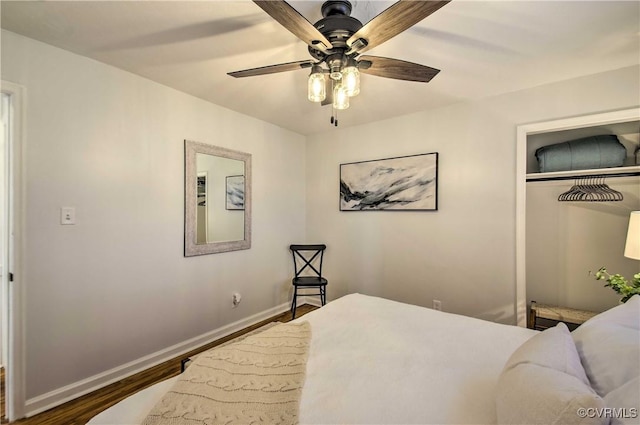 bedroom featuring a closet, wood finished floors, a ceiling fan, and baseboards