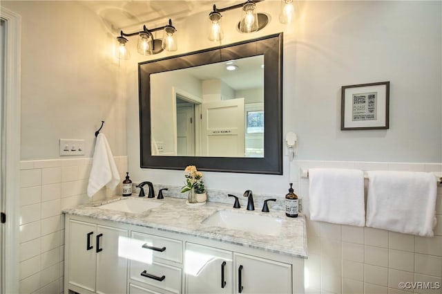 full bathroom featuring a sink, tile walls, and double vanity