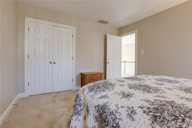 bedroom featuring baseboards, visible vents, a closet, and light colored carpet