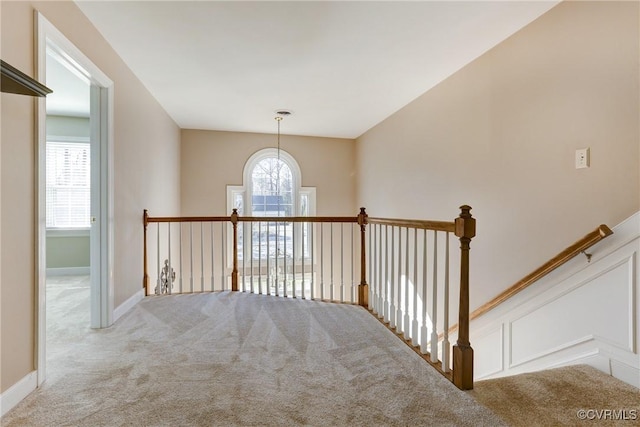 hallway with carpet and an upstairs landing