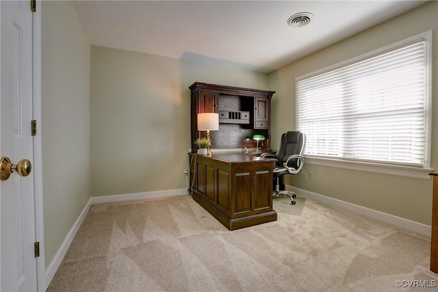 office area with baseboards, visible vents, and light colored carpet