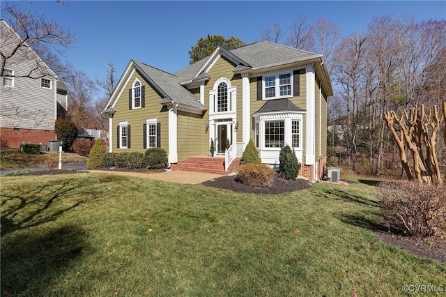 traditional-style house with a front yard and cooling unit