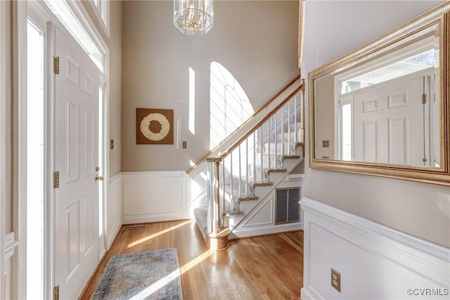 entryway featuring stairs, light wood finished floors, plenty of natural light, and visible vents