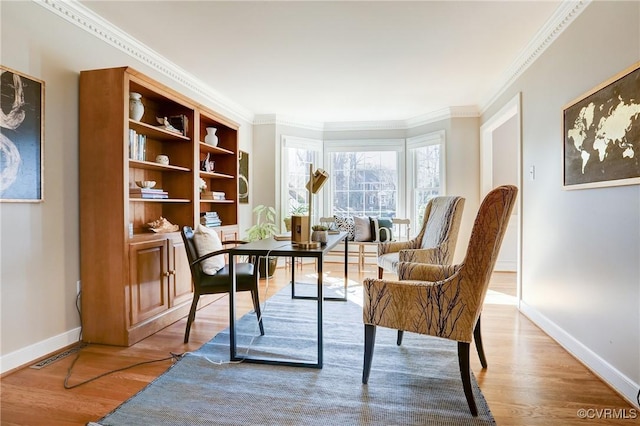 office featuring light wood finished floors, visible vents, baseboards, and crown molding