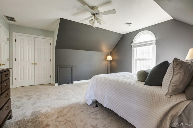 carpeted bedroom featuring lofted ceiling, a closet, and visible vents