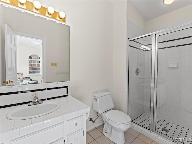 bathroom featuring vanity, a shower stall, toilet, and tile patterned floors