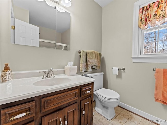 bathroom featuring baseboards, vanity, toilet, and tile patterned floors