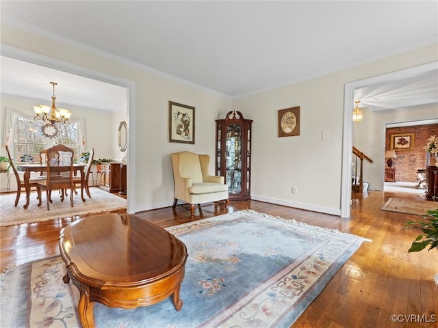 living area with an inviting chandelier, crown molding, stairway, and hardwood / wood-style floors