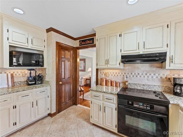 kitchen with range, light stone counters, ornamental molding, under cabinet range hood, and black microwave