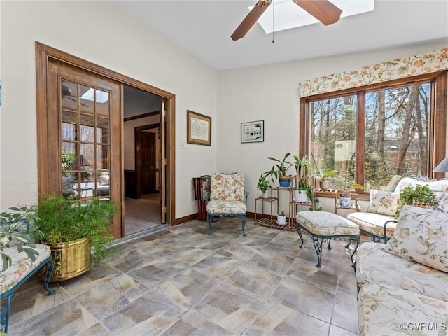 sitting room with ceiling fan and baseboards