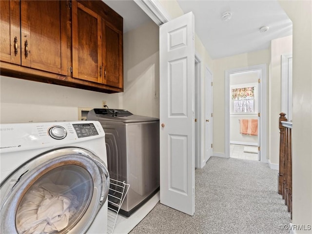 washroom with light carpet, independent washer and dryer, cabinet space, and baseboards