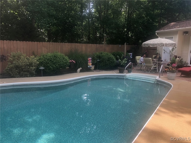 view of swimming pool featuring a patio area, fence, and a fenced in pool