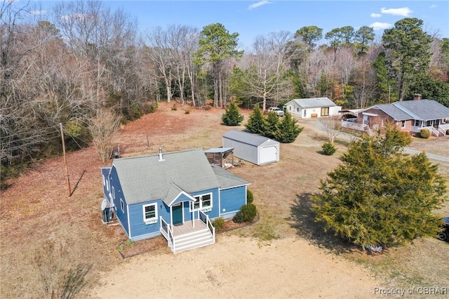 birds eye view of property featuring a wooded view