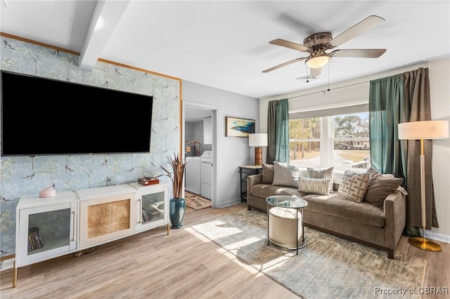 living room featuring ceiling fan, light wood-style flooring, baseboards, and separate washer and dryer