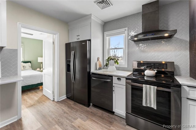 kitchen featuring wall chimney exhaust hood, black refrigerator with ice dispenser, backsplash, electric range, and dishwashing machine