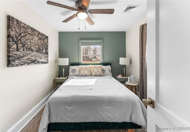 bedroom with a ceiling fan, baseboards, visible vents, and wood finished floors